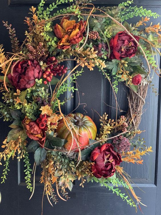 A Fall Wreath Of Leaves, Faux Bright Blooms, Pumpkins And Twigs Of Various Kinds Is Very Chic