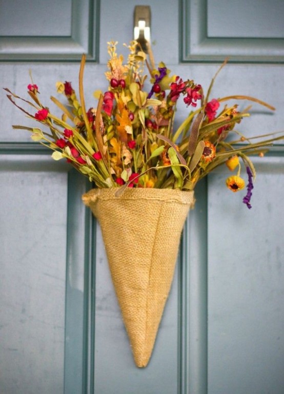 A Rustic Door Arrangement Of A Burlap Cone, Faux Blooms And Greenery Is A Nice Alternative To A Usual Door Wreath