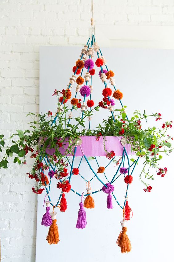 A Colorful Chandelier With Greenery, Bright Pompoms, Tassels And Wooden Beads Is A Cool Decoration For Any Space