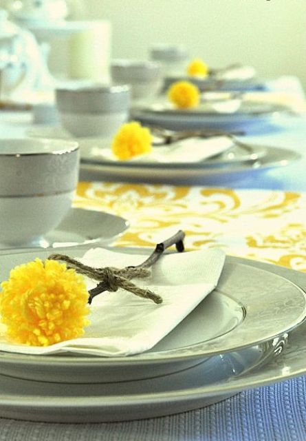 billy balls made of sticks and yellow pompoms are a nice way to accent place settings for spring