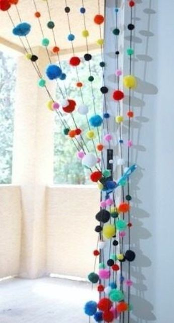 colorful pompom curtains to divide the balcony from the rest of the interior - it's an easy way to do that and you can DIY that