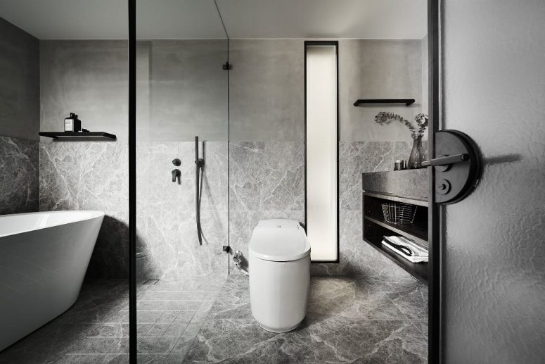 The Bathroom Is Done In Grey, With White Appliances And Black Touches