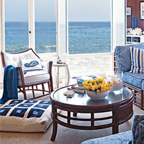 A Vintage Beach Sunroom With Dark And Blue And White Upholstery Furniture, A Dark Table And A Marvellous View