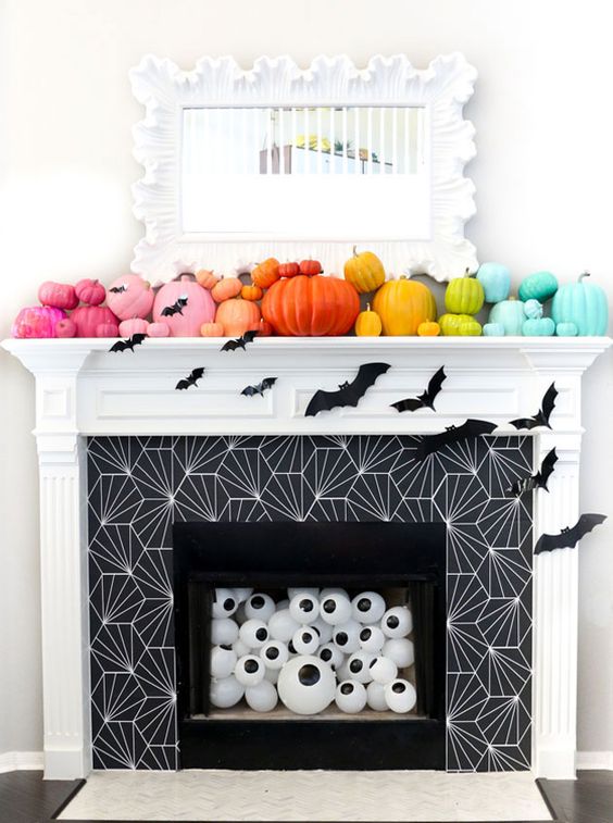 A Rainbow Pumpkin Mantel With Bats, Eyeballs In The Fireplace For Fun And Bold Halloween Styling