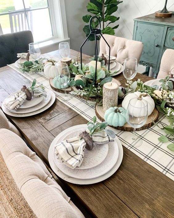 Faux Greenery And Faux Green And White Pumpkins, A Plaid Runner And Wood Slices For Pretty Rustic Thanksgiving Decor