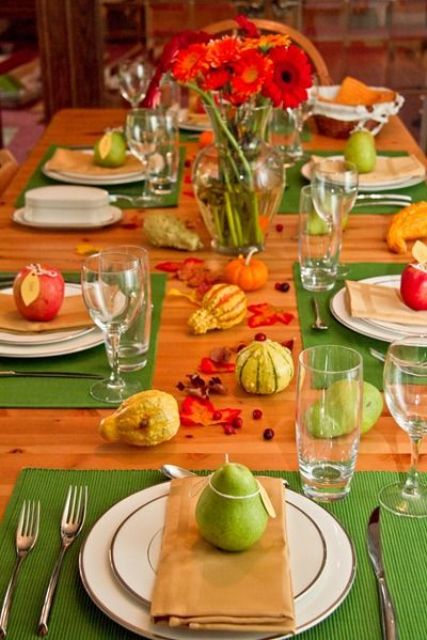 A Colorful Thanksgiving Tablescape With A Green Placemats, Green Gourds And Pears, Red Blooms And Apples Is Fun And Bold