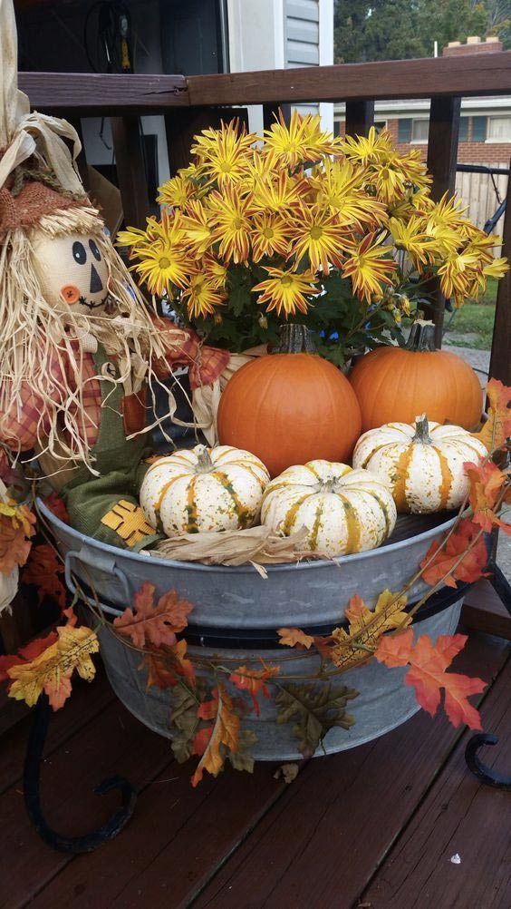 A Bucket With Bold Blooms, Leaves, Pumpkins And A Scarecrow Is A Pretty Outdoor Decoration For Thanksgiving