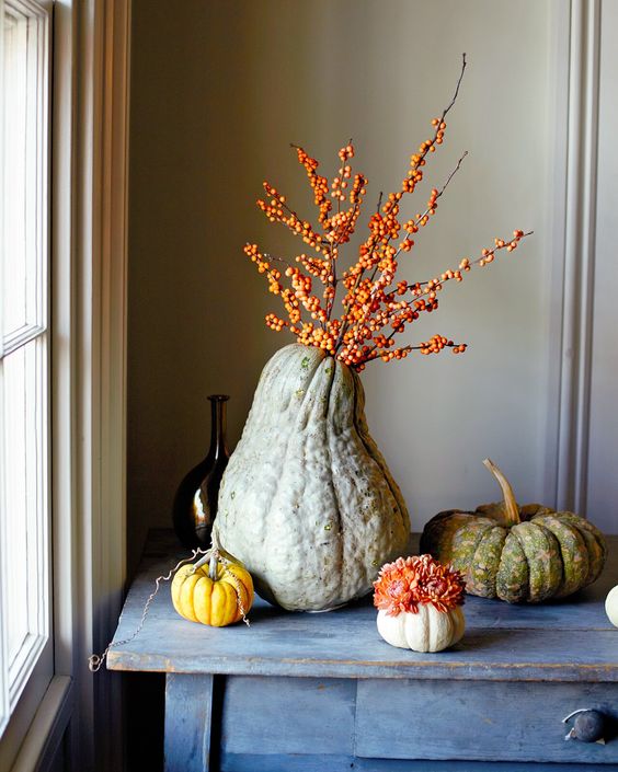 Heirloom Pumpkins With Blooms And An Oversized Gourd With Berried Branches Is A Lovely All-Natural Decoration