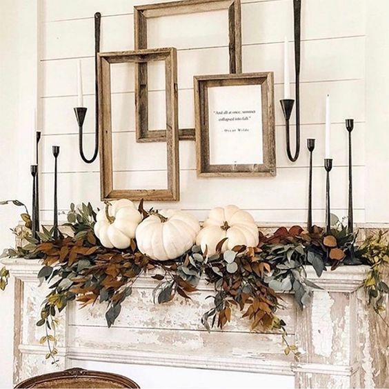 A Refined Vintage Thanksgiving Mantel With Lots Of Greenery And Dried Leaves, White Pumpkins, White Candles And Empty Frames For A Farmhouse Touch