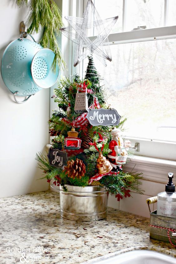 A Pretty Tabletop Christmas Tree Decorated With Pinecones And Mini Kitchen Appliances, Berries In A Bucket Is A Lovely Vintage Idea