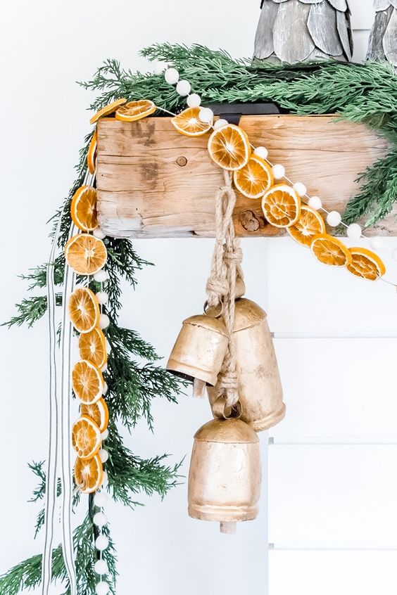 Natural Christmas Mantel Decor With Fir Branches, Dried Citrus Slices, Large Vintage Bells And Pompoms Is Gorgeous